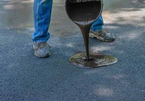 Sealcoating by Monmouth County contractor, worker pouring sealcoating on Monmouth driveway