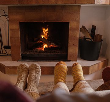 3-sets of socked feet in front a safe fireplace thanks to Lacey chimney maintenance