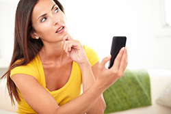 Person with a questioning look on their face with cell phone held up; Toms River website designer removes confusion